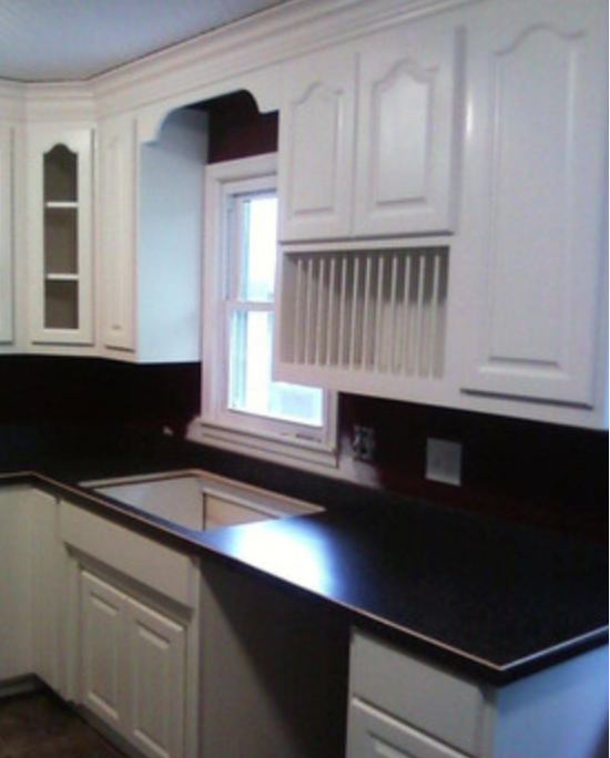 Custom built white kitchen cabinets with black countertop